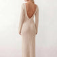 Woman wearing the Calixta Crochet Plunge Neck Maxi Dress in an elegant open-knit crochet design with a deep plunge V-neck, keyhole detail, long flared sleeves, low open back and fitted floor-length silhouette, ideal for beach holidays, festivals and summer occasion wear.
