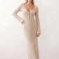 Woman wearing the Calixta Crochet Plunge Neck Maxi Dress in an elegant open-knit crochet design with a deep plunge V-neck, keyhole detail, long flared sleeves, low open back and fitted floor-length silhouette, ideal for beach holidays, festivals and summer occasion wear.
