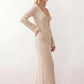 Woman wearing the Calixta Crochet Plunge Neck Maxi Dress in an elegant open-knit crochet design with a deep plunge V-neck, keyhole detail, long flared sleeves, low open back and fitted floor-length silhouette, ideal for beach holidays, festivals and summer occasion wear.