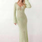 Woman wearing the Calixta Crochet Plunge Neck Maxi Dress in an elegant open-knit crochet design with a deep plunge V-neck, keyhole detail, long flared sleeves, low open back and fitted floor-length silhouette, ideal for beach holidays, festivals and summer occasion wear.
