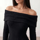 Woman wearing the Iustina Off Shoulder Fitted Maxi Dress featuring a Bardot neckline, soft draped shoulders, full-length sleeves, textured stretch knit fabric and a fitted floor-length silhouette, ideal for formal occasions and evening events.