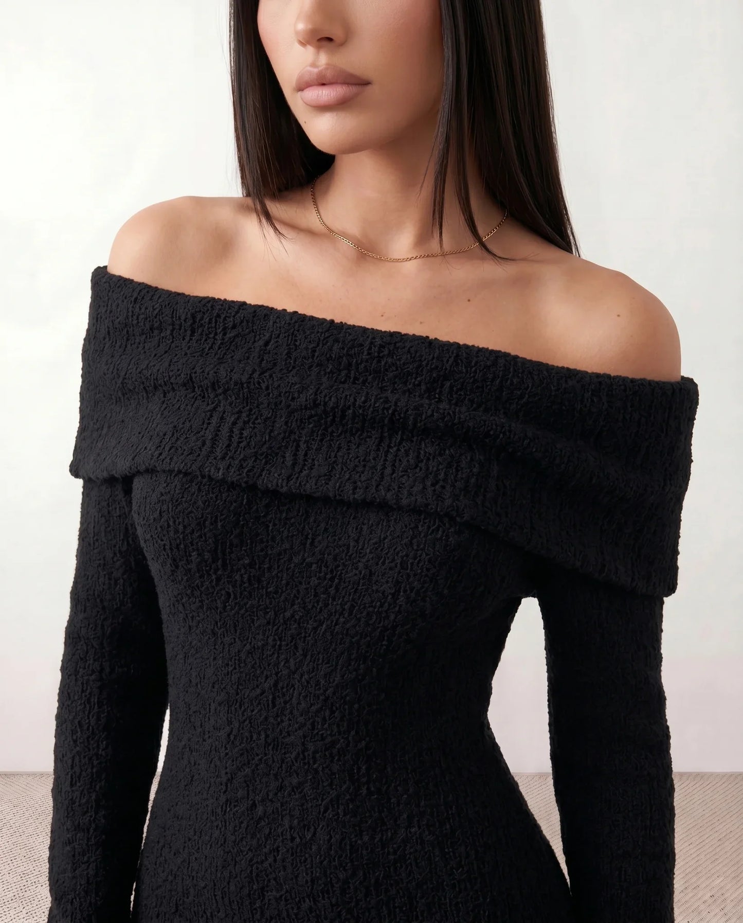 Woman wearing the Iustina Off Shoulder Fitted Maxi Dress featuring a Bardot neckline, soft draped shoulders, full-length sleeves, textured stretch knit fabric and a fitted floor-length silhouette, ideal for formal occasions and evening events.