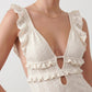 Woman wearing the crochet mermaid maxi dress featuring an intricate crochet knit, plunging V-neckline, ruffled shoulder straps, keyhole waist cut-out, adjustable lace-up open back, scalloped hem, and a figure-hugging maxi silhouette, ideal for weddings, cocktail parties, and elegant evening occasions.
