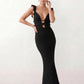 Woman wearing the crochet mermaid maxi dress featuring an intricate crochet knit, plunging V-neckline, ruffled shoulder straps, keyhole waist cut-out, adjustable lace-up open back, scalloped hem, and a figure-hugging maxi silhouette, ideal for weddings, cocktail parties, and elegant evening occasions.
