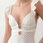 Woman wearing the crochet mermaid maxi dress featuring an intricate crochet knit, plunging V-neckline, ruffled shoulder straps, keyhole waist cut-out, adjustable lace-up open back, scalloped hem, and a figure-hugging maxi silhouette, ideal for weddings, cocktail parties, and elegant evening occasions.