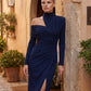 Woman wearing the Asymmetric Neck Open Back Midi Dress featuring an asymmetric mock-neck halter, off-shoulder ruched detailing, long fitted sleeves, an elegant open back, fitted midi silhouette and front slit, styled for weddings, cocktail parties and formal occasions.