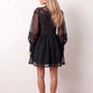 Woman wearing the Lace Openwork Mini Dress featuring intricate lace-inspired openwork, a mandarin collar, decorative front buttons, long sleeves, a fitted waist, and a scalloped mini hem, ideal for weddings, cocktail parties, and elegant occasions.
