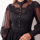 Woman wearing the Lace Openwork Mini Dress featuring intricate lace-inspired openwork, a mandarin collar, decorative front buttons, long sleeves, a fitted waist, and a scalloped mini hem, ideal for weddings, cocktail parties, and elegant occasions.