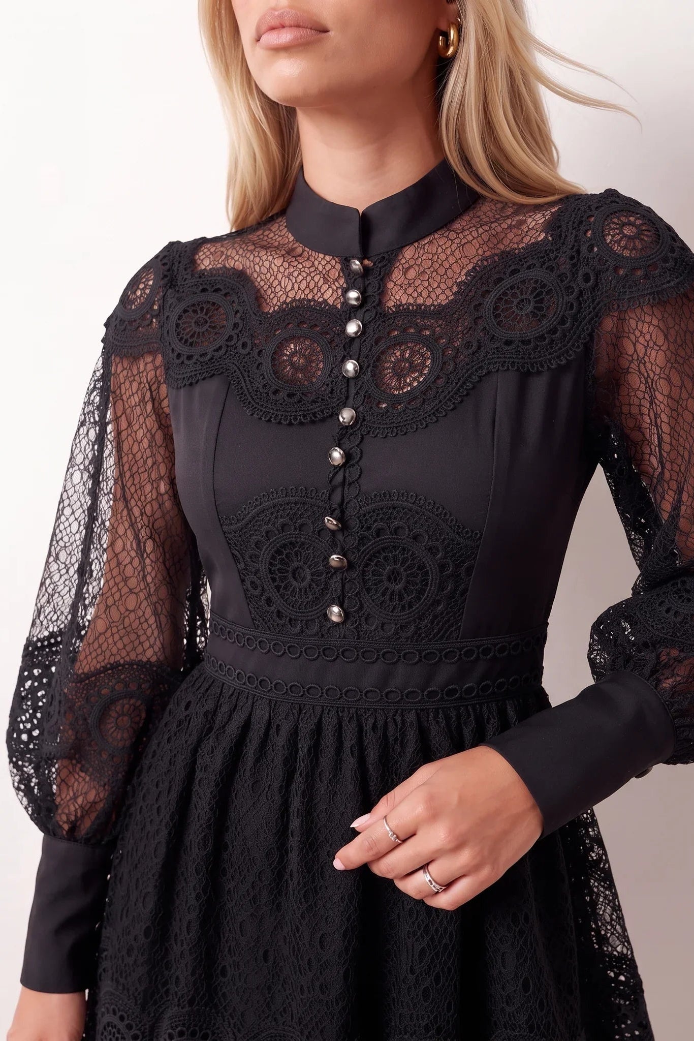 Woman wearing the Lace Openwork Mini Dress featuring intricate lace-inspired openwork, a mandarin collar, decorative front buttons, long sleeves, a fitted waist, and a scalloped mini hem, ideal for weddings, cocktail parties, and elegant occasions.