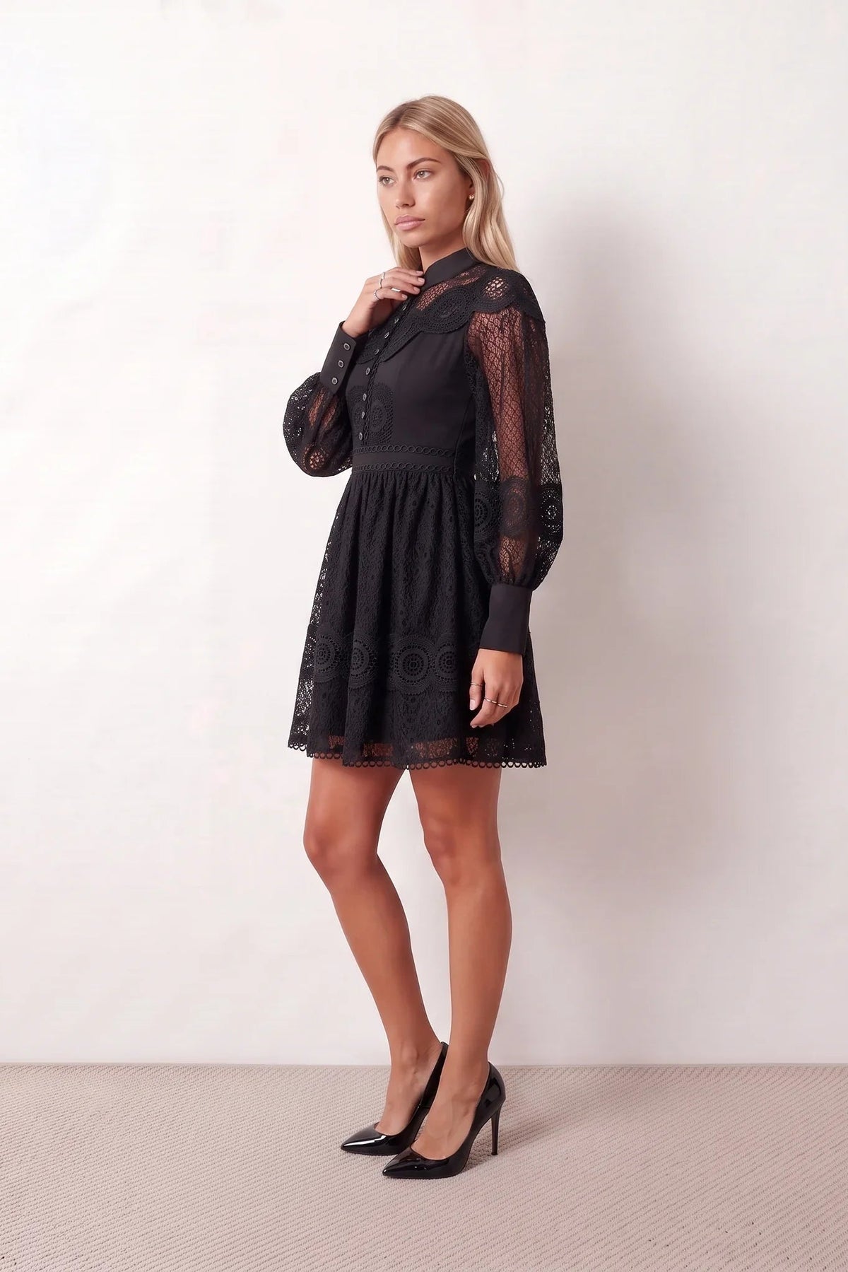 Woman wearing the Lace Openwork Mini Dress featuring intricate lace-inspired openwork, a mandarin collar, decorative front buttons, long sleeves, a fitted waist, and a scalloped mini hem, ideal for weddings, cocktail parties, and elegant occasions.
