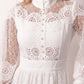Woman wearing the Lace Openwork Mini Dress featuring intricate lace-inspired openwork, a mandarin collar, decorative front buttons, long sleeves, a fitted waist, and a scalloped mini hem, ideal for weddings, cocktail parties, and elegant occasions.