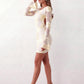 Woman wearing the Anahera open back fitted mini dress with sheer embroidered long sleeves, a round neckline, side cut-out details, and a sleek sheath silhouette, ideal for cocktail parties and evening occasions.