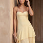 Elsie spaghetti strap sweetheart maxi dress with a structured corset bodice, delicate spaghetti straps, sheer panel detailing, an asymmetric three-tier chiffon skirt with ruffle hem, front slit, and a flowing high-low silhouette, perfect for weddings and special occasions.