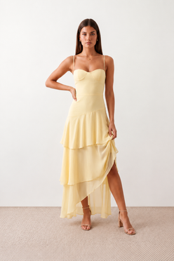 Elsie spaghetti strap sweetheart maxi dress with a structured corset bodice, delicate spaghetti straps, sheer panel detailing, an asymmetric three-tier chiffon skirt with ruffle hem, front slit, and a flowing high-low silhouette, perfect for weddings and special occasions.