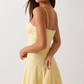 Elsie spaghetti strap sweetheart maxi dress with a structured corset bodice, delicate spaghetti straps, sheer panel detailing, an asymmetric three-tier chiffon skirt with ruffle hem, front slit, and a flowing high-low silhouette, perfect for weddings and special occasions.
