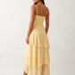 Elsie spaghetti strap sweetheart maxi dress with a structured corset bodice, delicate spaghetti straps, sheer panel detailing, an asymmetric three-tier chiffon skirt with ruffle hem, front slit, and a flowing high-low silhouette, perfect for weddings and special occasions.