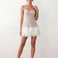 Mariela sequined spaghetti strap mini dress with a sheer sequined bodice, open low back featuring beaded cage straps, layered ostrich feather trim, and a straight-cut mini silhouette for cocktail parties and evening events.
