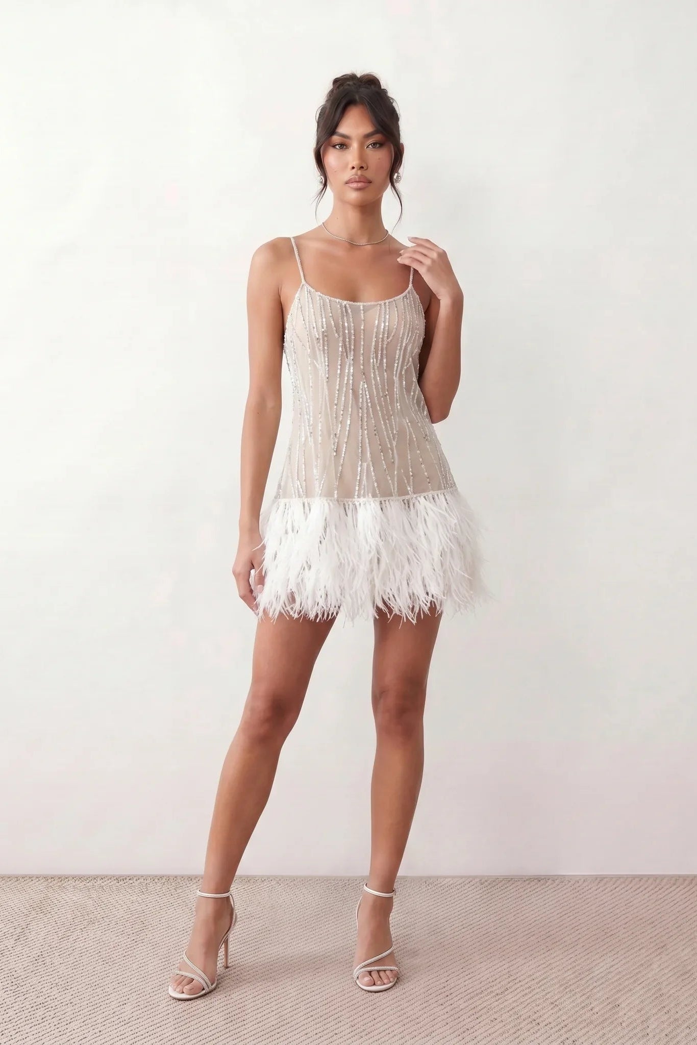 Mariela sequined spaghetti strap mini dress with a sheer sequined bodice, open low back featuring beaded cage straps, layered ostrich feather trim, and a straight-cut mini silhouette for cocktail parties and evening events.