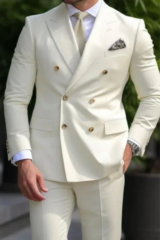 White double-breasted suit with gold buttons on a blurred green background