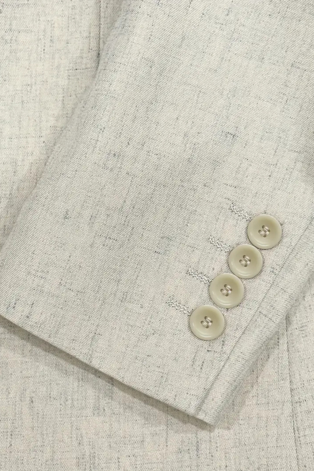 Close-up of a textured fabric with buttons on a light gray background