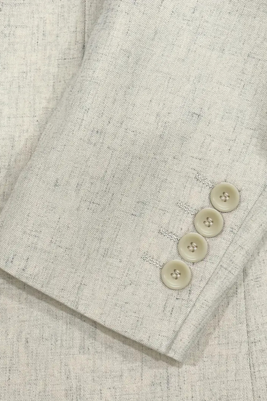 Close-up of a textured fabric with buttons on a light gray background