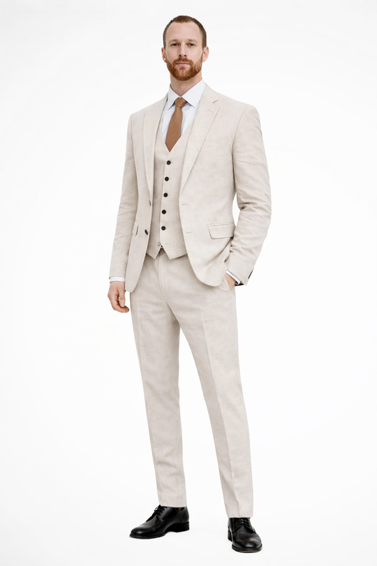 Man wearing a beige suit with a white shirt and brown tie on a white background