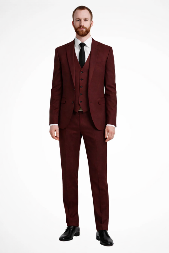 Man wearing a burgundy suit with a white shirt and black tie on a white background