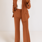 Brown suit with white top on a plain background