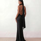 Woman wearing the Winnie satin halter maxi dress featuring a glossy satin finish, halter neckline with tie-back detail, open draped back, and a floor-length relaxed silhouette.