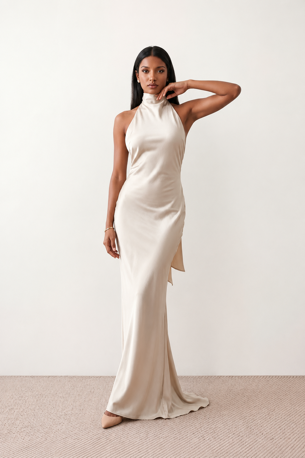 Woman wearing the Winnie satin halter maxi dress featuring a glossy satin finish, halter neckline with tie-back detail, open draped back, and a floor-length relaxed silhouette.