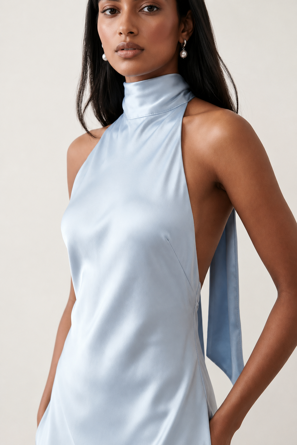 Woman wearing the Winnie satin halter maxi dress featuring a glossy satin finish, halter neckline with tie-back detail, open draped back, and a floor-length relaxed silhouette.