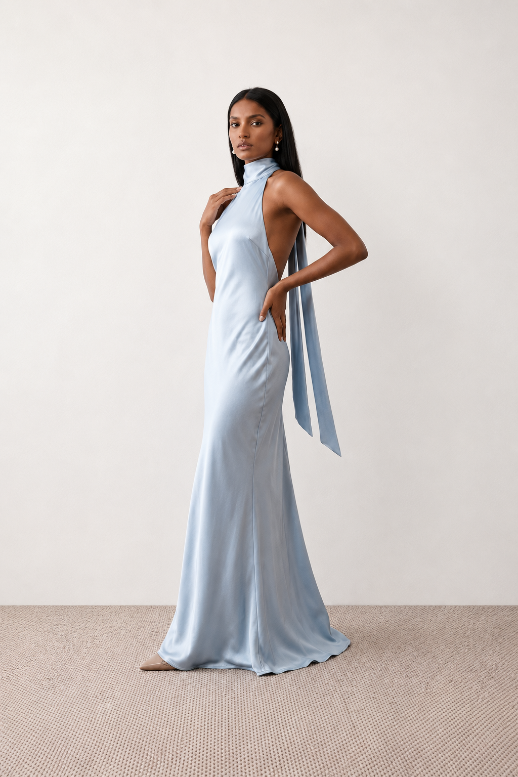 Woman wearing the Winnie satin halter maxi dress featuring a glossy satin finish, halter neckline with tie-back detail, open draped back, and a floor-length relaxed silhouette.
