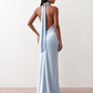 Woman wearing the Winnie satin halter maxi dress featuring a glossy satin finish, halter neckline with tie-back detail, open draped back, and a floor-length relaxed silhouette.
