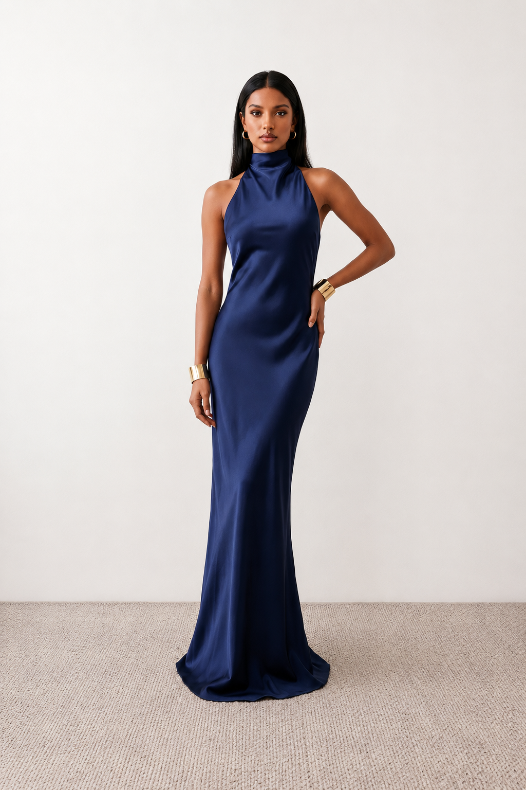 Woman wearing the Winnie satin halter maxi dress featuring a glossy satin finish, halter neckline with tie-back detail, open draped back, and a floor-length relaxed silhouette.