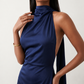 Woman wearing the Winnie satin halter maxi dress featuring a glossy satin finish, halter neckline with tie-back detail, open draped back, and a floor-length relaxed silhouette.