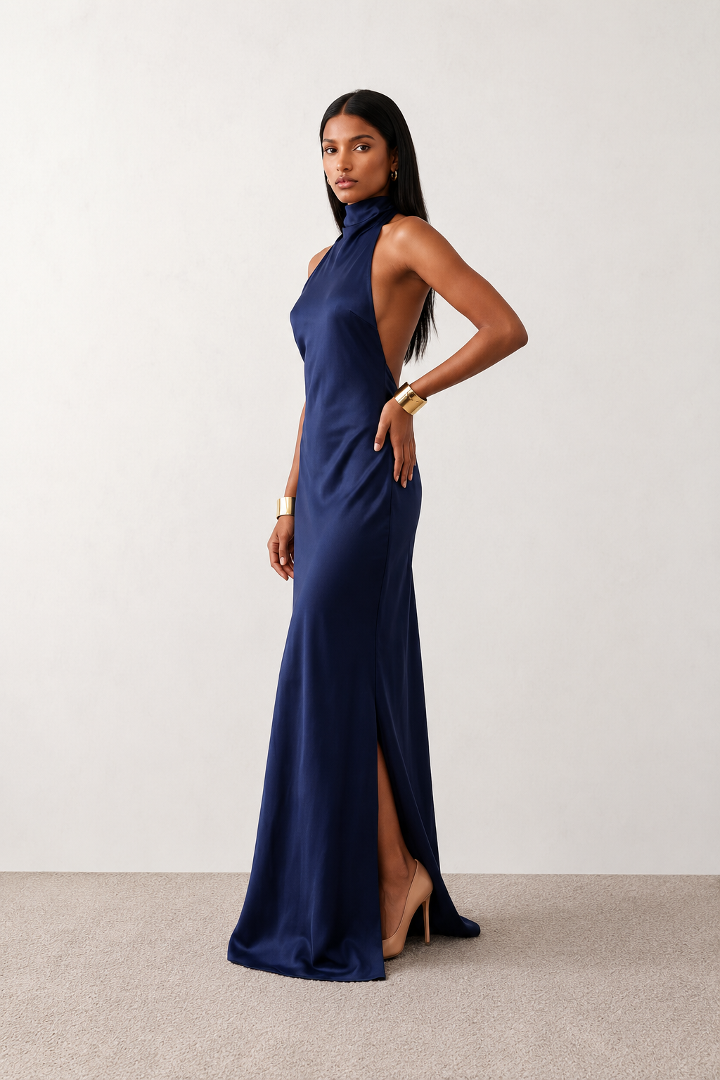 Woman wearing the Winnie satin halter maxi dress featuring a glossy satin finish, halter neckline with tie-back detail, open draped back, and a floor-length relaxed silhouette.