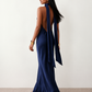 Woman wearing the Winnie satin halter maxi dress featuring a glossy satin finish, halter neckline with tie-back detail, open draped back, and a floor-length relaxed silhouette.