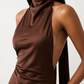Woman wearing the Winnie satin halter maxi dress featuring a glossy satin finish, halter neckline with tie-back detail, open draped back, and a floor-length relaxed silhouette.