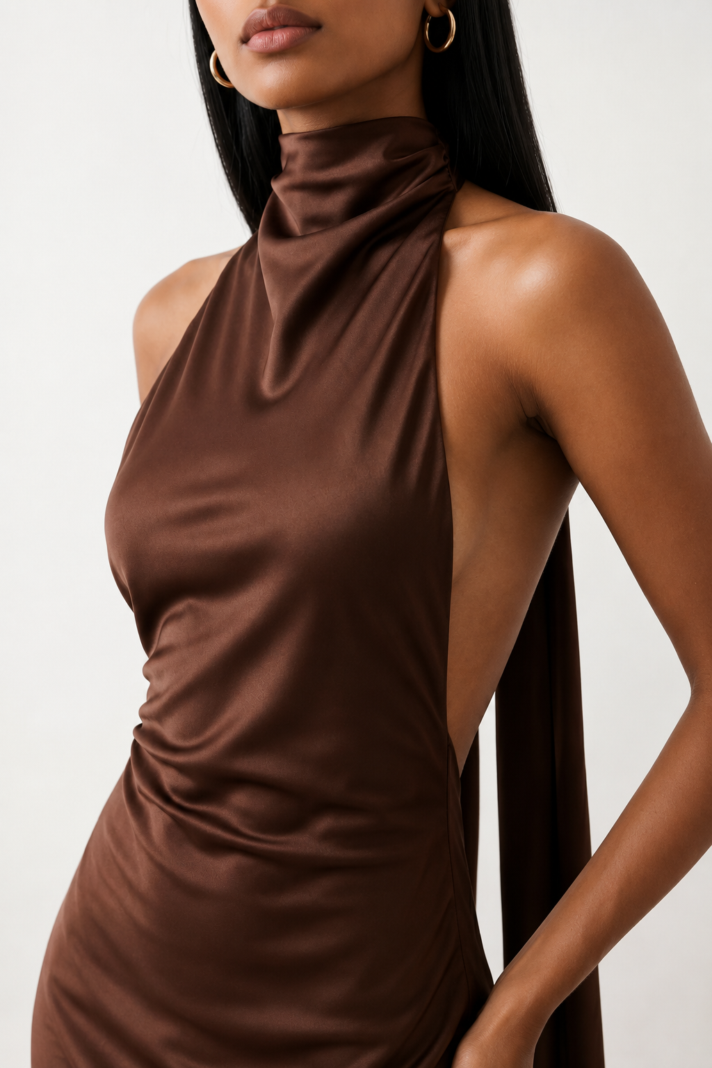 Woman wearing the Winnie satin halter maxi dress featuring a glossy satin finish, halter neckline with tie-back detail, open draped back, and a floor-length relaxed silhouette.