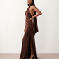 Woman wearing the Winnie satin halter maxi dress featuring a glossy satin finish, halter neckline with tie-back detail, open draped back, and a floor-length relaxed silhouette.