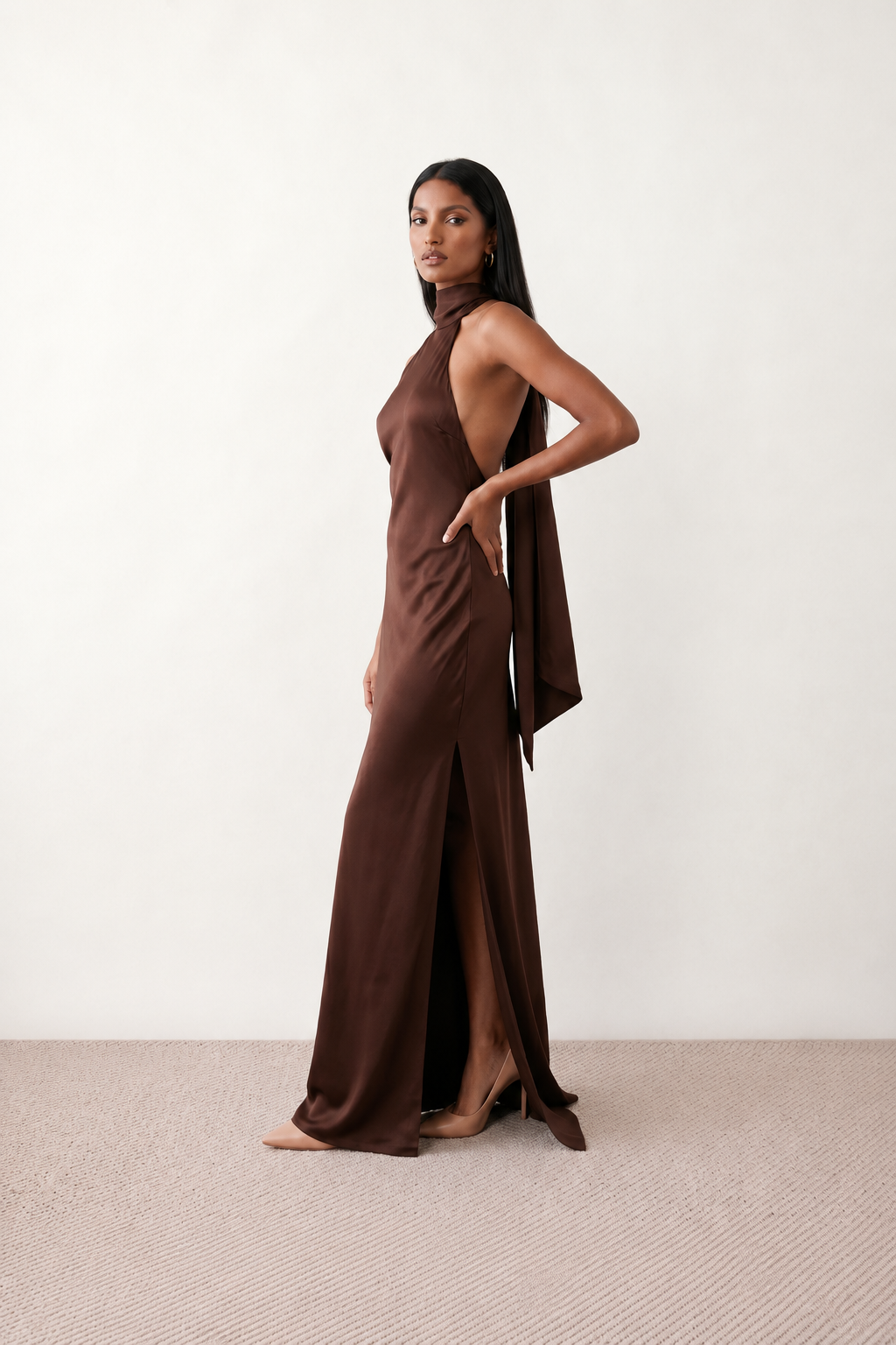 Woman wearing the Winnie satin halter maxi dress featuring a glossy satin finish, halter neckline with tie-back detail, open draped back, and a floor-length relaxed silhouette.