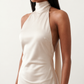 Woman wearing the Winnie satin halter maxi dress featuring a glossy satin finish, halter neckline with tie-back detail, open draped back, and a floor-length relaxed silhouette.