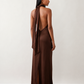Woman wearing the Winnie satin halter maxi dress featuring a glossy satin finish, halter neckline with tie-back detail, open draped back, and a floor-length relaxed silhouette.