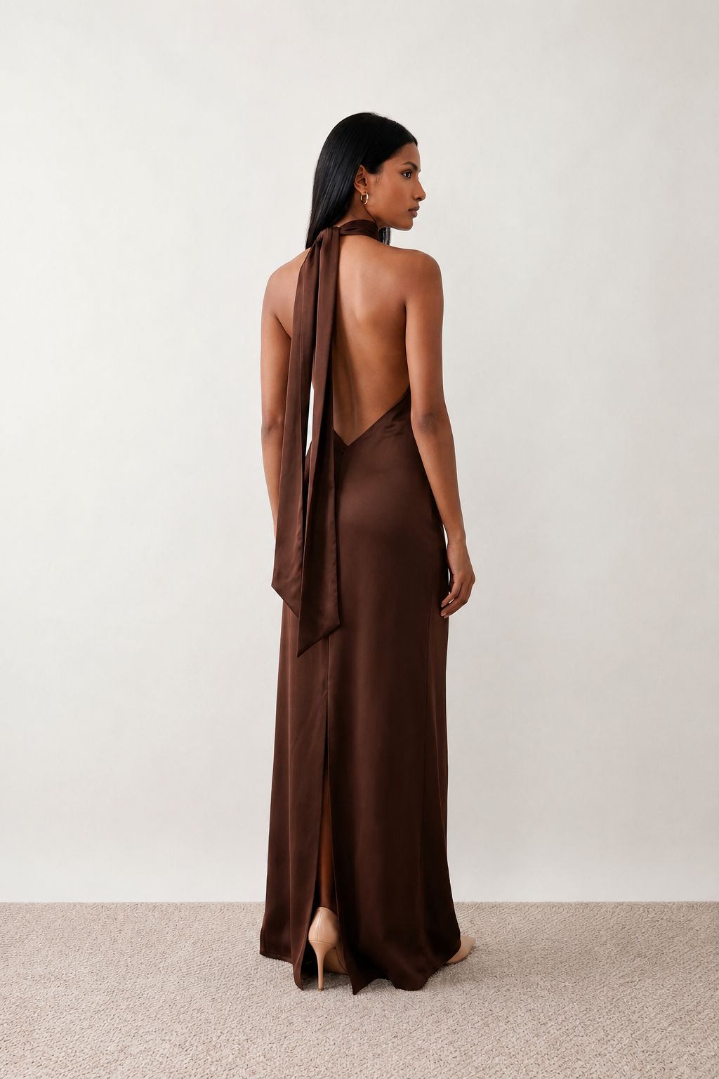 Woman wearing the Winnie satin halter maxi dress featuring a glossy satin finish, halter neckline with tie-back detail, open draped back, and a floor-length relaxed silhouette.