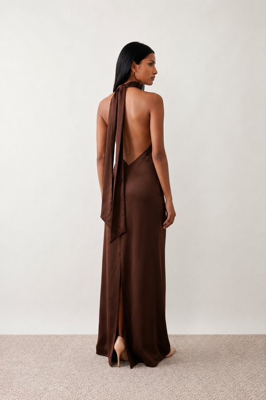 Woman wearing the Winnie satin halter maxi dress featuring a glossy satin finish, halter neckline with tie-back detail, open draped back, and a floor-length relaxed silhouette.