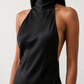 Woman wearing the Winnie satin halter maxi dress featuring a glossy satin finish, halter neckline with tie-back detail, open draped back, and a floor-length relaxed silhouette.