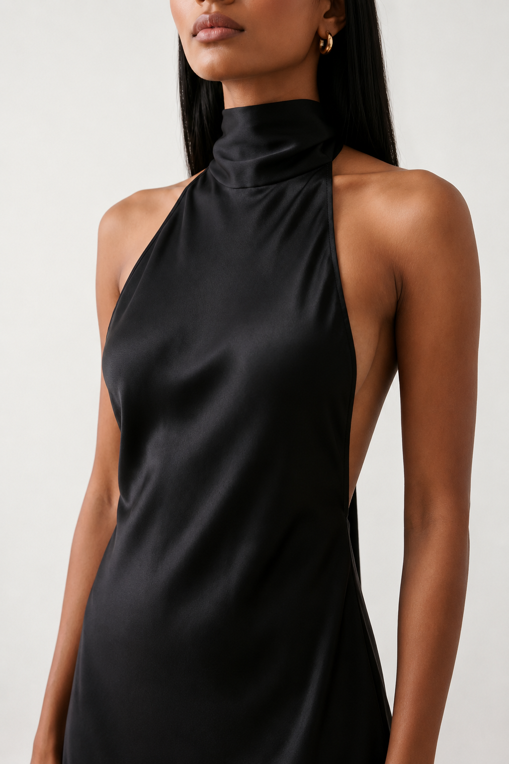 Woman wearing the Winnie satin halter maxi dress featuring a glossy satin finish, halter neckline with tie-back detail, open draped back, and a floor-length relaxed silhouette.