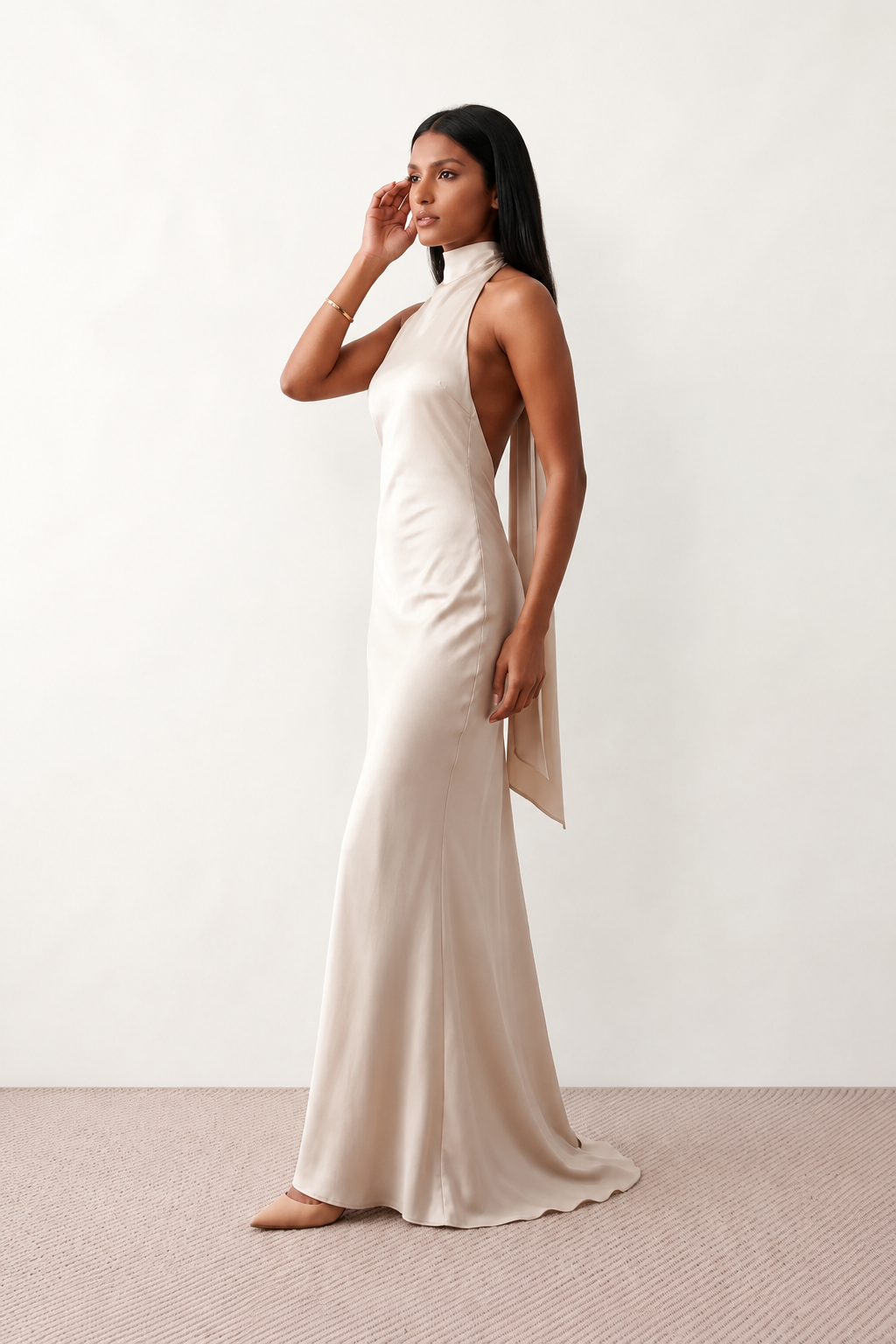 Woman wearing the Winnie satin halter maxi dress featuring a glossy satin finish, halter neckline with tie-back detail, open draped back, and a floor-length relaxed silhouette.