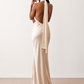 Woman wearing the Winnie satin halter maxi dress featuring a glossy satin finish, halter neckline with tie-back detail, open draped back, and a floor-length relaxed silhouette.