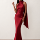 Woman wearing the Winnie satin halter maxi dress featuring a glossy satin finish, halter neckline with tie-back detail, open draped back, and a floor-length relaxed silhouette.